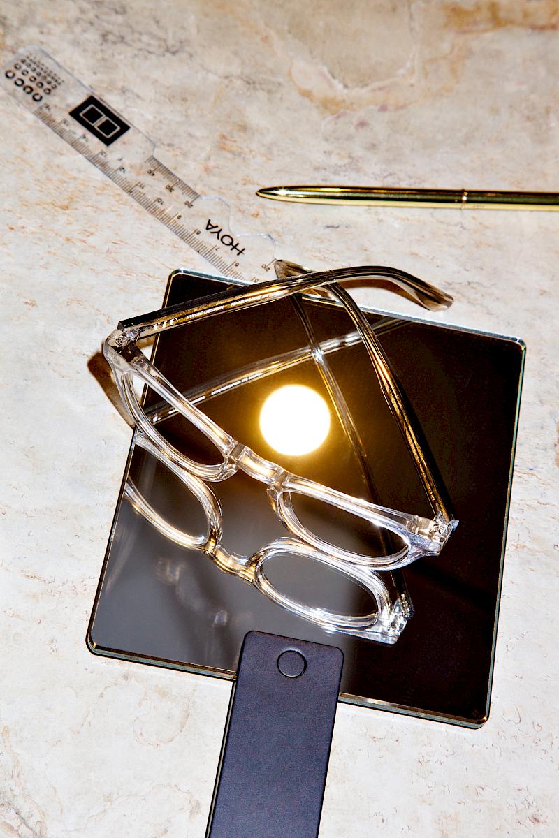 Fake sun reflecting on a mirror with a pair of glasses