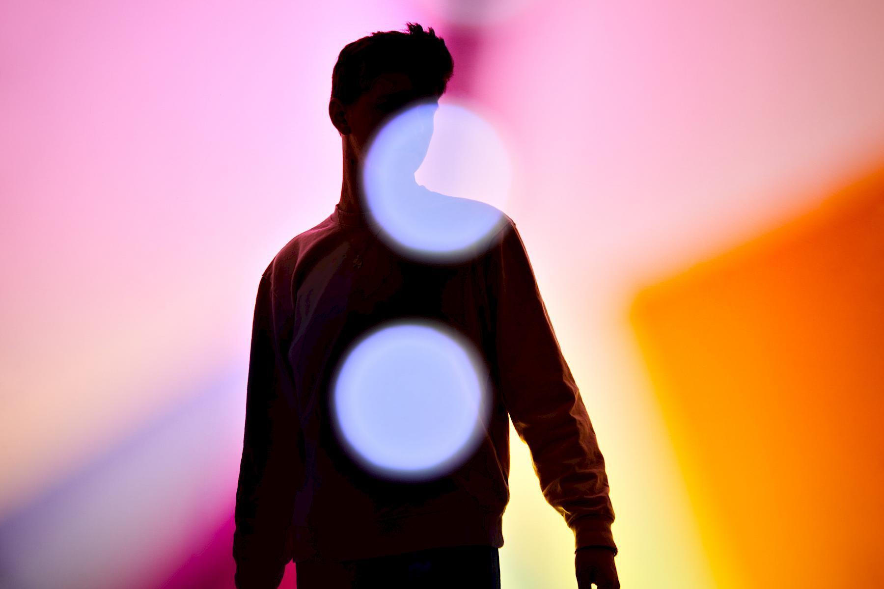 Silhouette of Jan against a colourful light play. Portrait for NZZ am Sonntag